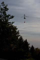 Helicopter flying in the sky pouring water on fires
