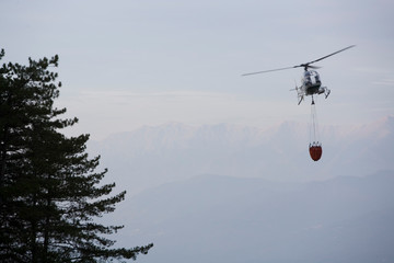 Fototapeta na wymiar Helicopter flying in the sky pouring water on fires