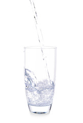 Pouring of fresh water into glass on white background