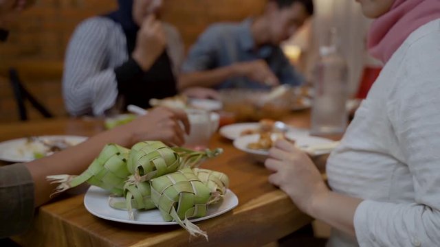ketupat on dining table with people eating on the background