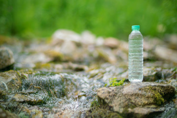 Plastic bottle with fresh cool water on nature background.