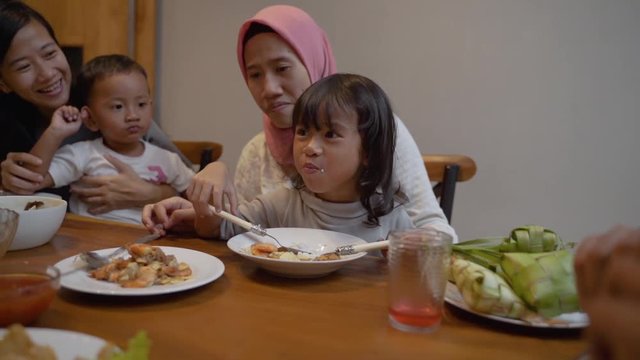 portrait of mother feeding their child on dinner at home