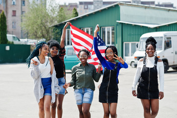 Group of five african american woman walking together on parking with USA flag.