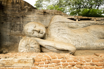Stunning view of the beautiful statue of the Reclining Buddha carved in stone. The Gal Vihara also known as Gal Viharaya is a rock temple situated in the ancient city of Polonnaruwa, Sri Lanka.