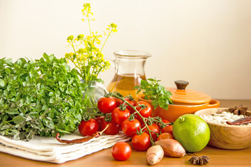Food and utensils to prepare food. Fresh basil, cherry tomatoes, beans, olive oil, lime, onion, spices, saucepan, jars in cereals. Culinary background. Copy space