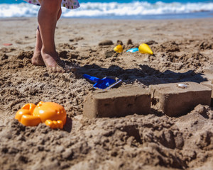 Adorable little girl making sand castle at beach