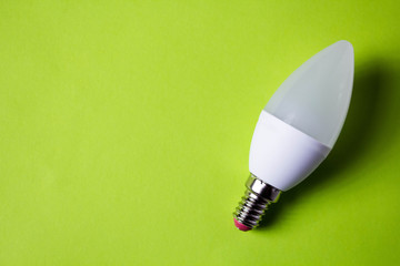 Energy saving light bulb on green background with copyspace