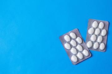 blister with white pills on blue background with copyspase