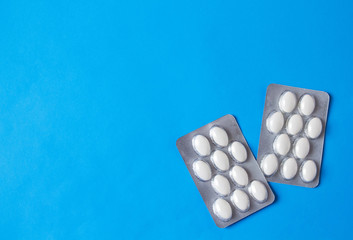 blister with white pills on blue background with copyspase