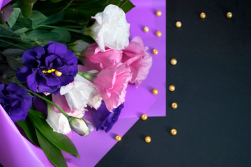 Pink, white, purple flower blooming bouquet on black background with copy space