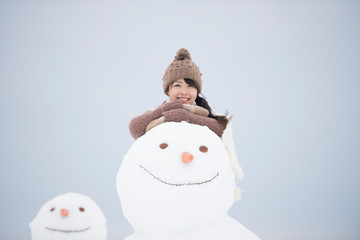 微笑む女性と雪だるま