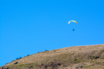Fototapeta na wymiar An adventurer glides through the sky over the Yorkshire Moorlands on a clear sunny day