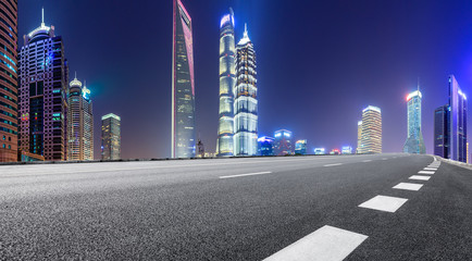 Shanghai modern commercial office buildings and empty asphalt highway at night,panoramic view