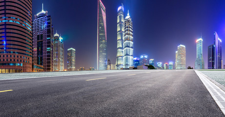 Shanghai modern commercial office buildings and empty asphalt highway at night,panoramic view