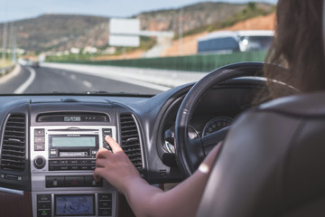 Fototapeta premium The girl is driving on the highway in Cyprus. View from the back seat of the car on the windshield, road and the driver