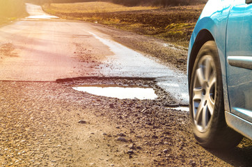 Car and winter pothole on open road