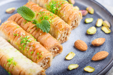 Baklava, traditional arabic sweets in gray ceramic plate on a gray concrete background. close up.
