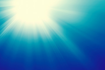 Sun on a blue sky with rays and flare, abstract background