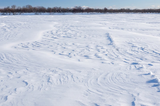 snow dunes on the surface of the frozen river Pinega. Arkhangelsk region. Russia