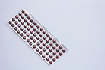 Set of plastic blisters with brown round pills. On white background.