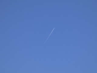 avión surcando el cielo azul y dejando una estela de color blanco