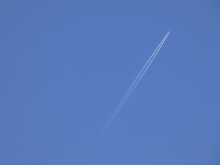 avión surcando el cielo azul y dejando una estela de color blanco