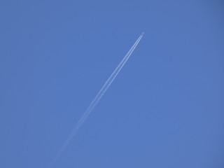 avión surcando el cielo azul y dejando una estela de color blanco