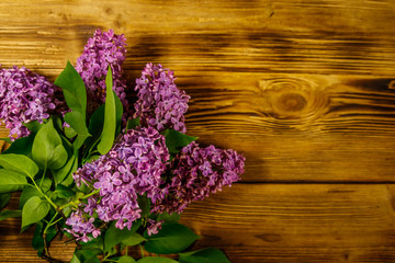 Purple lilac on wooden background. Top view, copy space