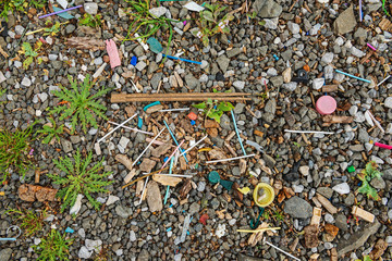 Garbage on the beach near the big city. Used dirty plastic sticks and other garbage. Environmental pollution.