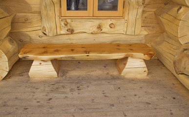 wooden bench of logs on the porch of the house