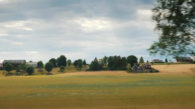 Travel in the outback of Norway, ride along farmland against the backdrop of a dramatic sky