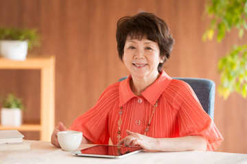 タブレットPCを操作するシニア女性