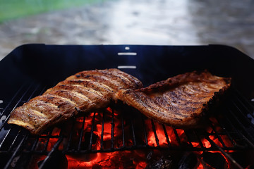 pork ribs on the grill cooking coals / fresh meat pork cooked on charcoal, summer home cooked meal, grilled ribs