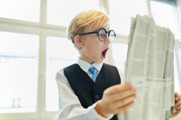 Kind als Geschäftsmann beim Lesen der Tageszeitung