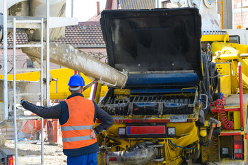 Construction worker standing near cement mixer
