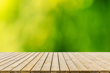 Empty wood plank table top with blur park green nature background