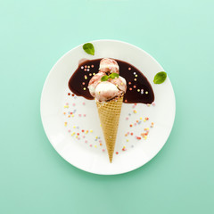 Ice cream in waffle cone with syrup and sprinkles
