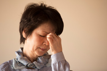 目の疲れに悩むシニア女性