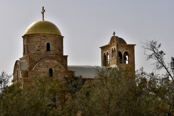 Fototapeta na wymiar St John the Baptist Orthodox Church with Trees in Foreground, Jordan