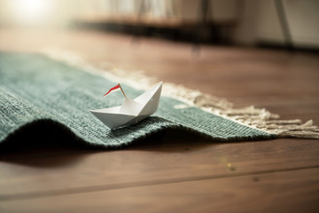 Urlaub zu Hause | Papierschiff auf Teppich-Wellen
