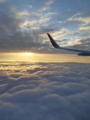 Obraz premium Beautiful sunset sky above clouds with dramatic light. Cabin view from airplane 