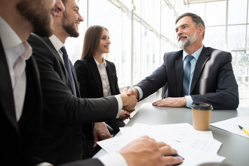 Business people shaking hands while working in the creative office
