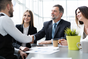 Business people shaking hands while working in the creative office