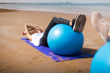 Fototapeta na wymiar Woman exercising with pilates ball on the beach