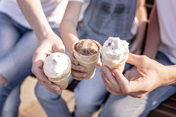 Ice cream in women's and children's hands. Happy family hands. Happy family concept.