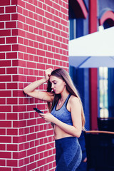 Slim girl listening to music in the smartphone after running