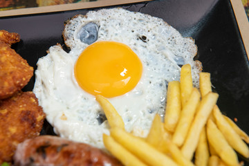 Plato de huevo, salchicha, patatas y ensalada