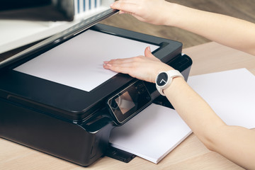 Woman making photocopy using copier in office