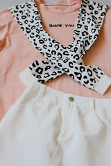 Casual and trendy clothes, coral-colored T-shirt, leopard sweatshirt and white jeans dress. Trends 2019 year. Thank you.