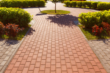 The figure track in the park is lined with concrete tiles of two colors.